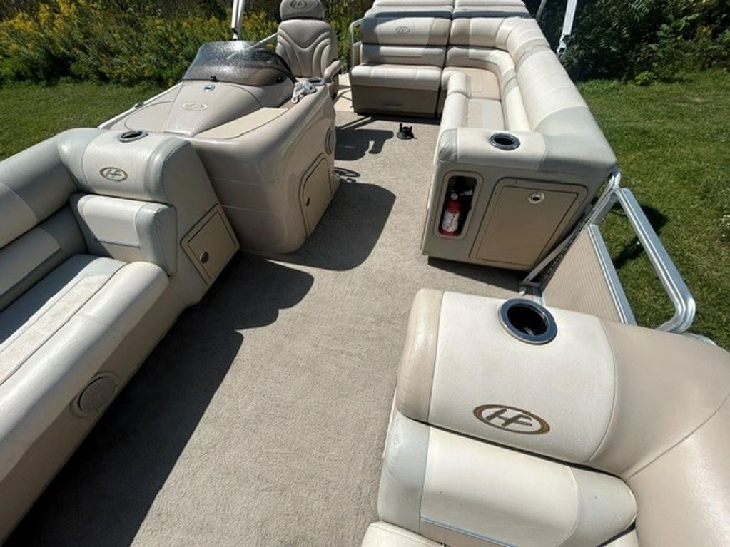 Interior seating area of a pontoon boat with beige cushions.