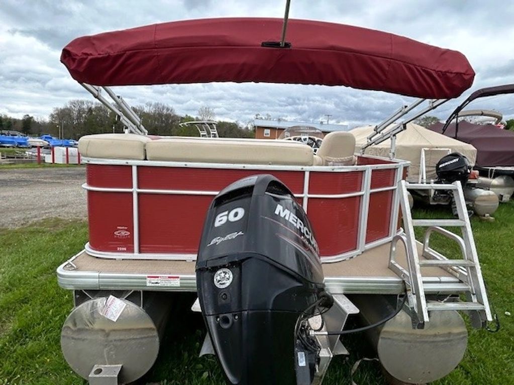 Red pontoon boat with beige seats and a Mercury 60 outboard motor.