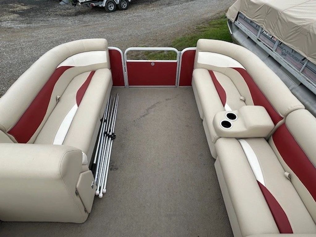 Interior seating of a pontoon boat with cushioned benches and a cup holder.