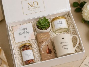 Elegant gift box with mug, candle, nuts, chocolate, succulent, and birthday card.