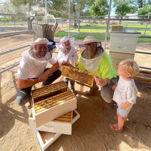 Family exploring beekeeping with honeycomb frames.