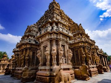 Intricately carved ancient temple under a bright blue sky.