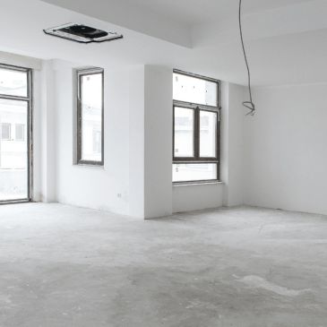 Empty room with white walls and concrete floor.