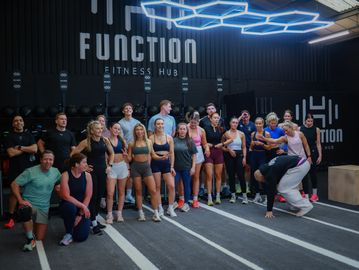 Group of people posing together in a fitness gym.