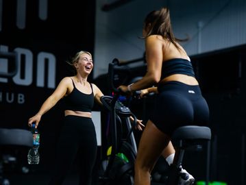 Two women exercising and enjoying a workout session indoors.