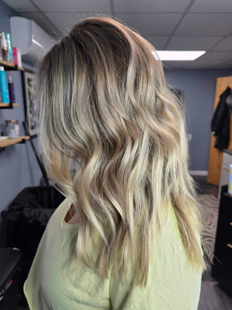 Client displays beautiful results after a hair color session.