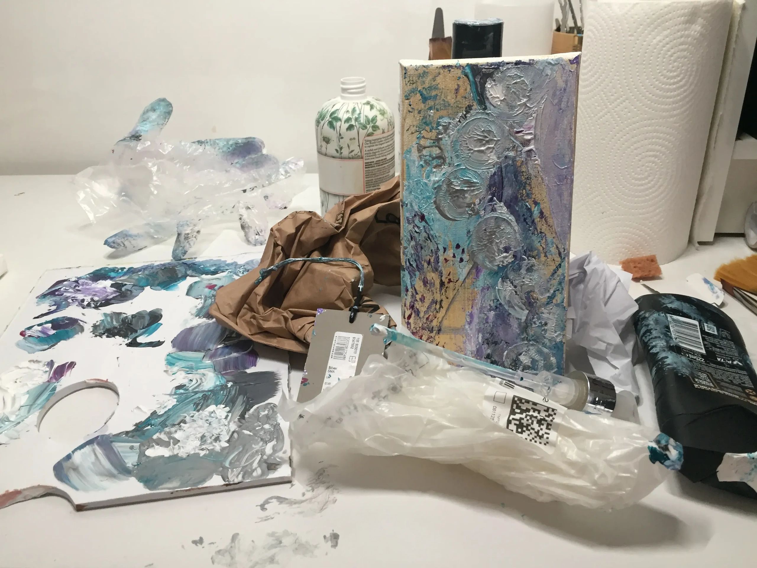Photograph of the abstract painting of rubbish with the materials used to create the painting.