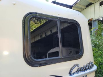 Window of a beige Casita camper trailer.