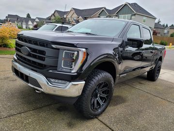 Black pickup truck parked on driveway.