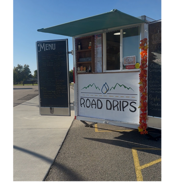 Food truck named Road Drips with a menu board and autumn decorations.