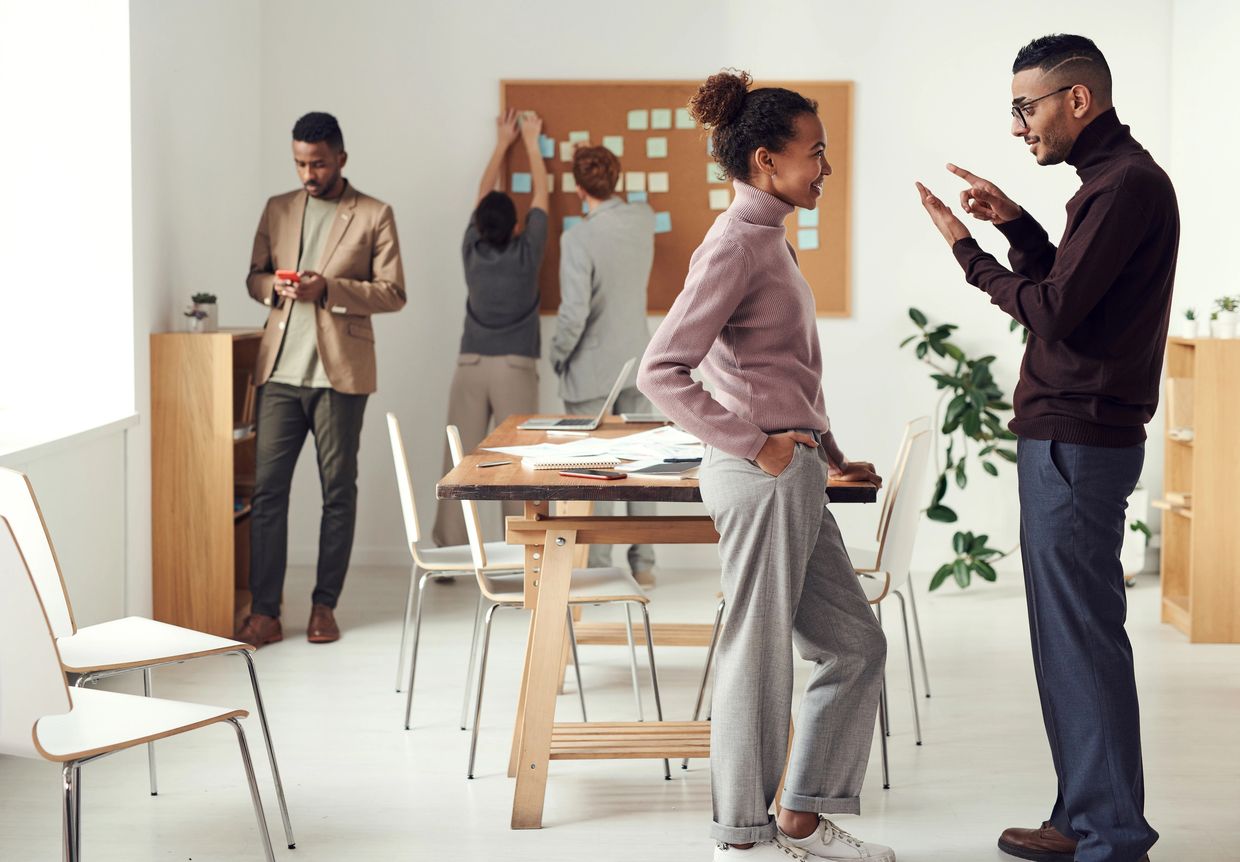 Colleagues engaging in discussions and teamwork in a modern office space.