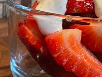 Close-up of strawberries with cream in a glass.