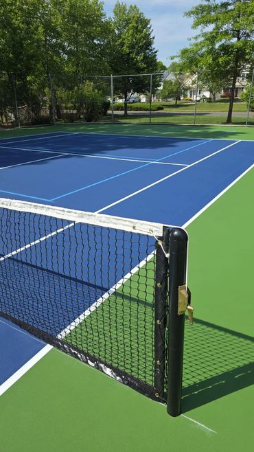 A well-maintained outdoor tennis court on a sunny day.
