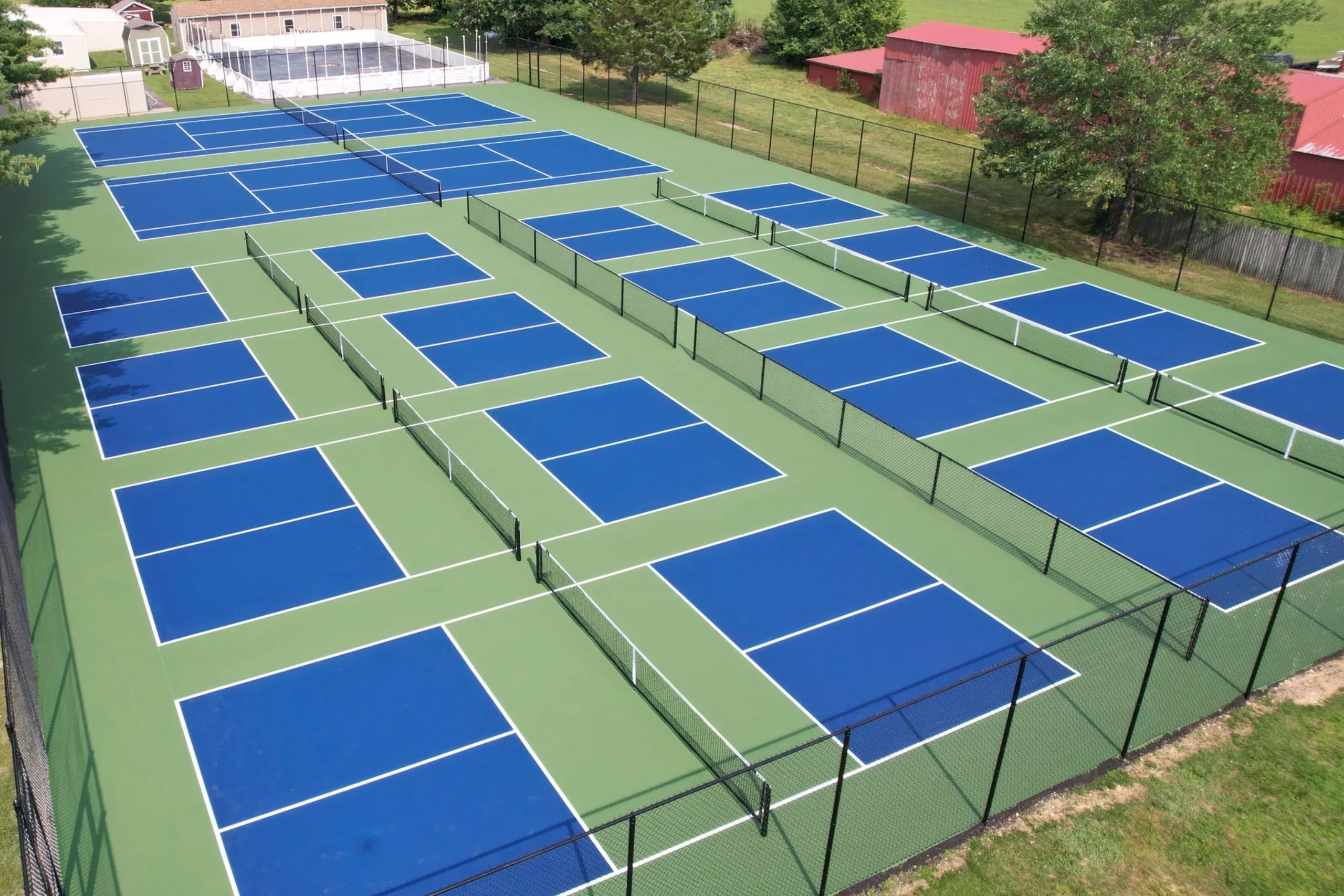 Tennis and pickleball courts with bright blue playing surfaces and green surrounding areas.