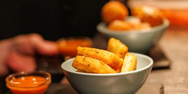 Golden fried snacks served with dipping sauce in small bowls.
