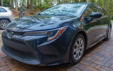 Close-up of a black Toyota car with water droplets.