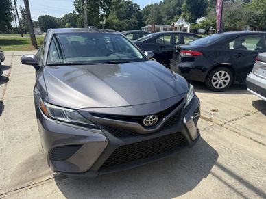 Front view of a gray Toyota car parked on a sunny day.