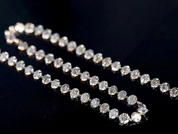 Elegant diamond necklace on black background.