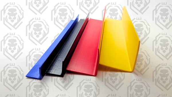 Four colorful plastic corner protectors in blue, black, red, and yellow.