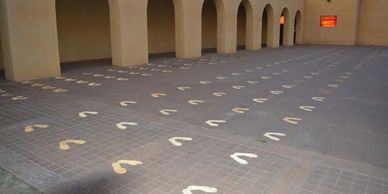 Footprints painted on the ground leading towards an arched corridor.