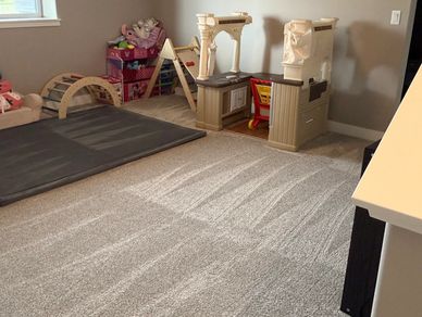 A clean and organized kids' playroom with toys and a play kitchen.
