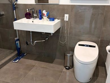 Modern bathroom with wall-mounted sink and smart toilet.