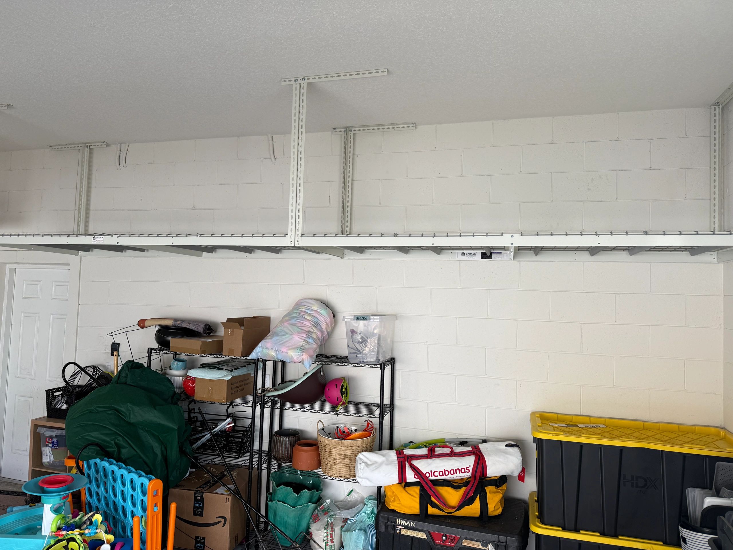 Garage storage shelves and bins with various items and toys.
