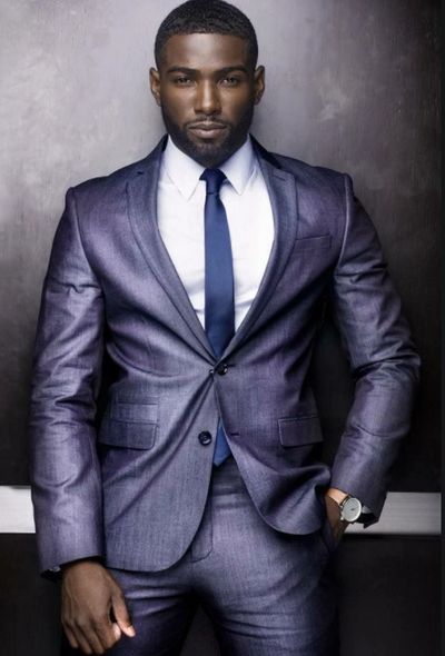Man in a sharp purple suit with a blue tie.
