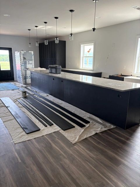 Modern kitchen with a large island and materials laid out for installation.
