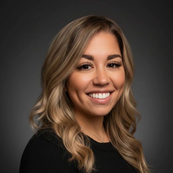 A scenic view of mountains under a clear blue sky with lush greenery in the foreground.