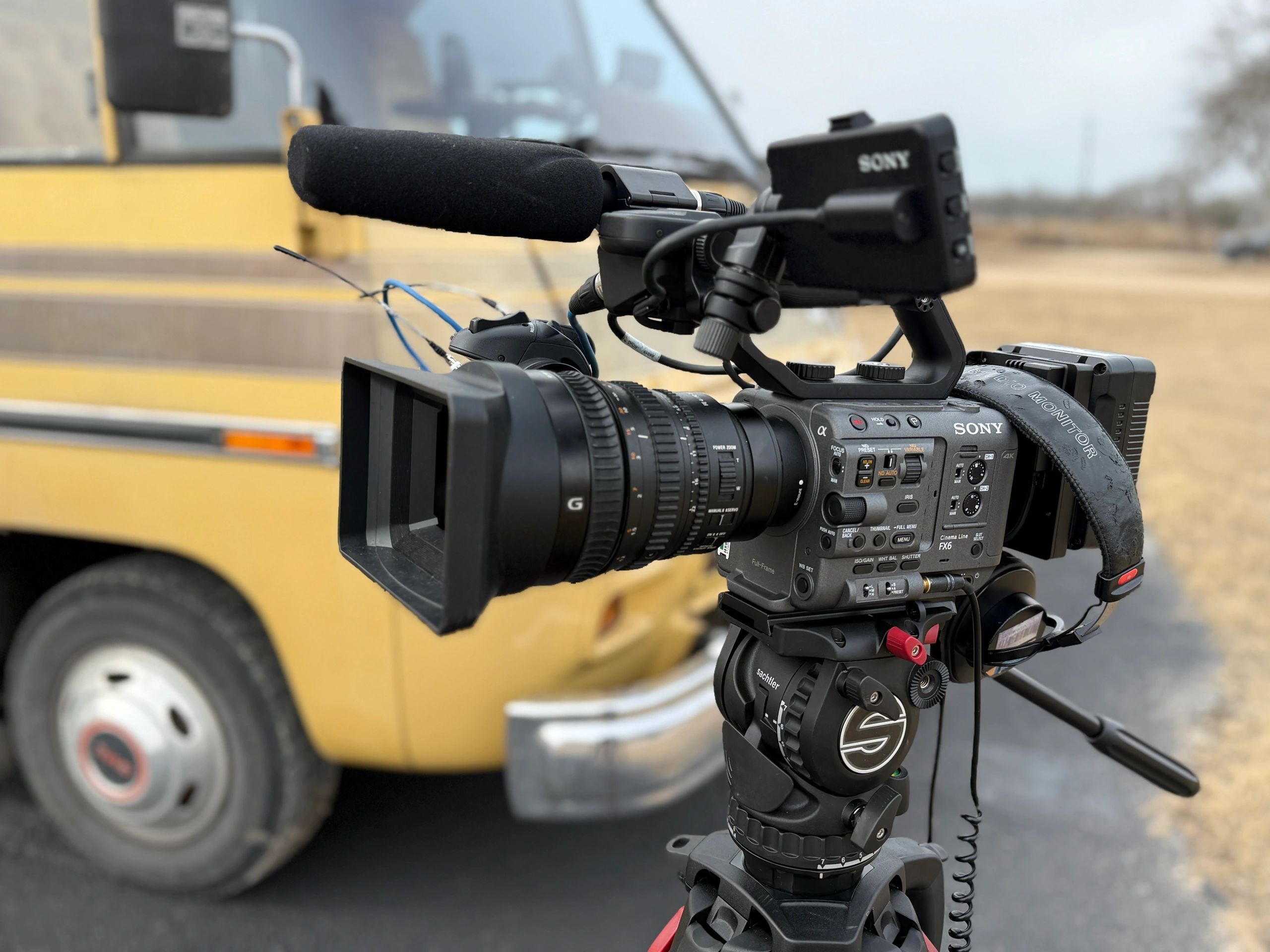 Professional Sony video camera with microphone and accessories on tripod.