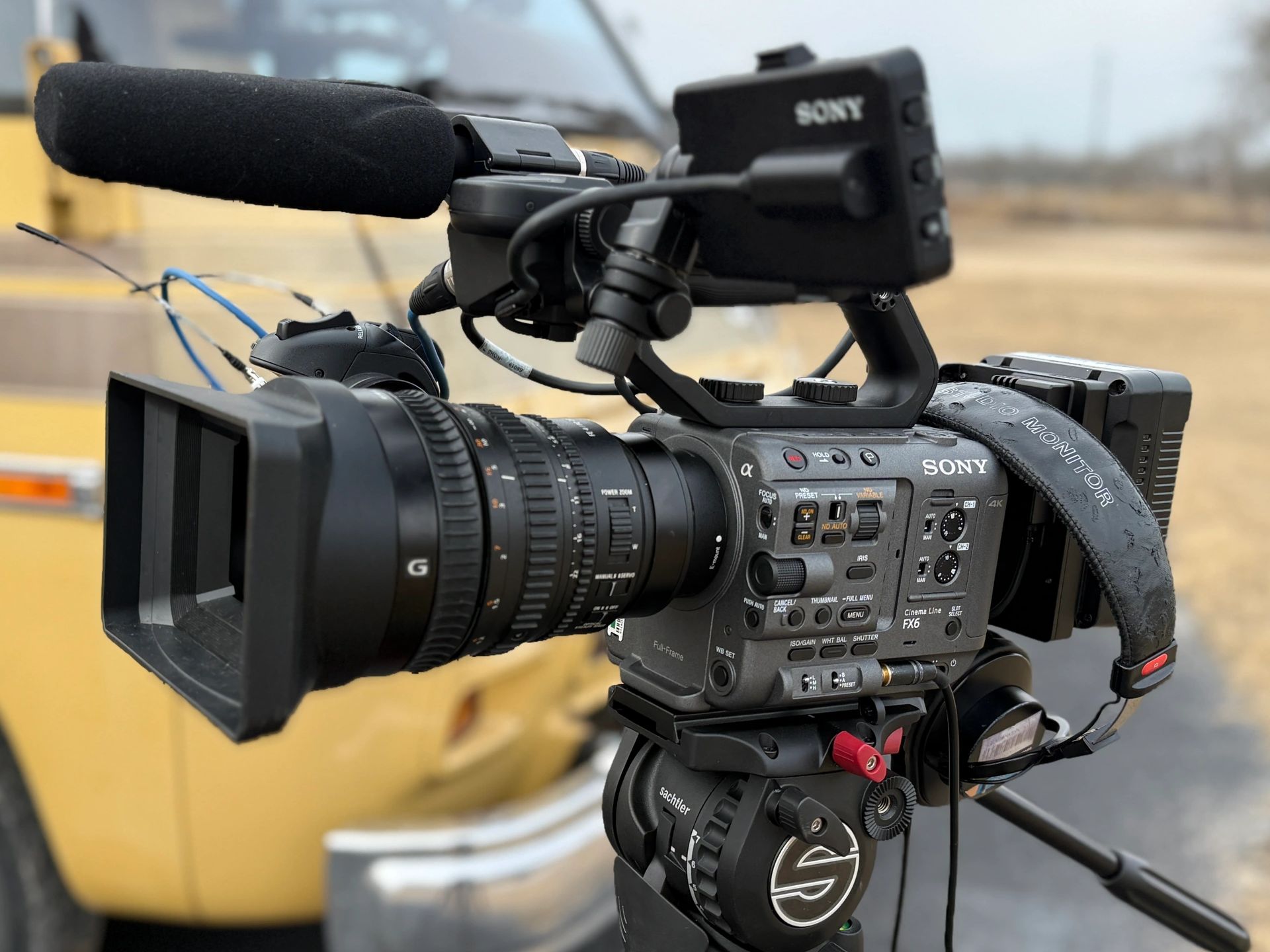 Professional Sony video camera with microphone and accessories on tripod.