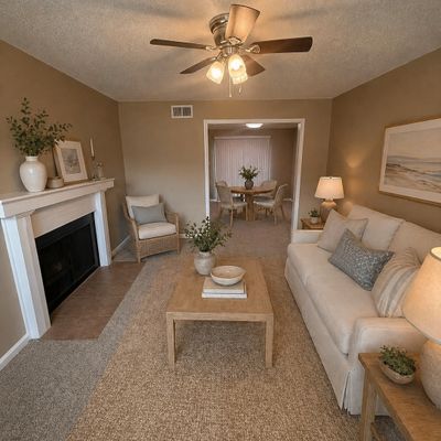 Cozy beige living room with a fireplace, neutral furniture, and natural decor.