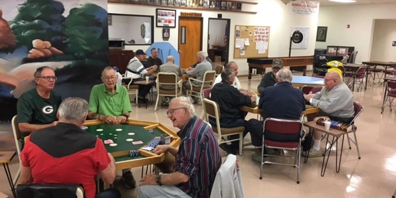 Groups of elderly men playing cards in a community center.