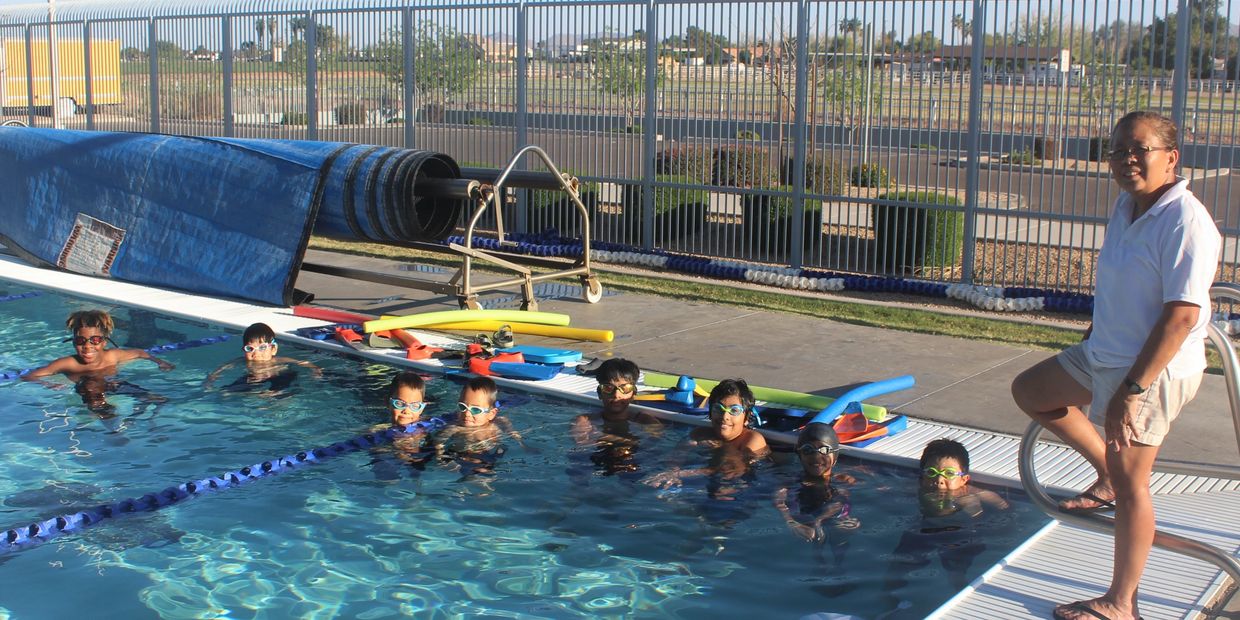 Eight Fast Track Swim Team members with coach at Gilbert Arizona swim facility.