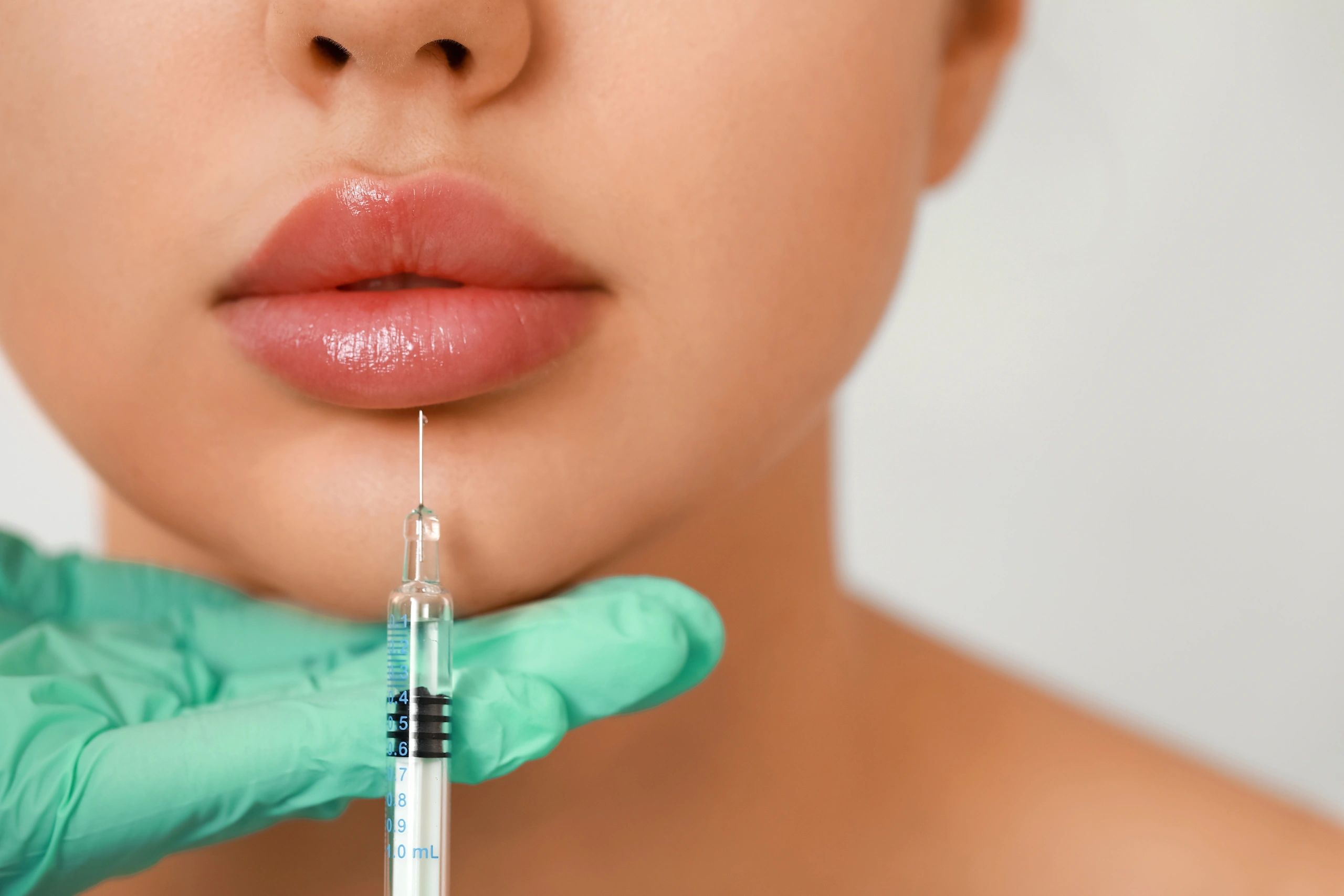 close picture of lips and a syringe