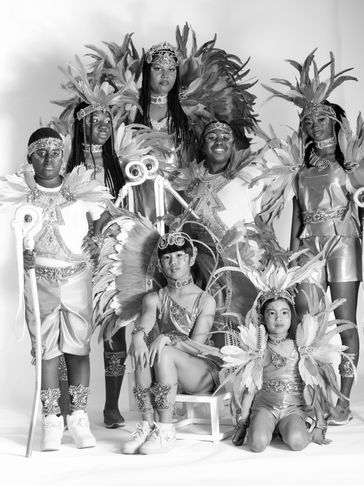 Group portrait of children in elaborate feathered carnival costumes.