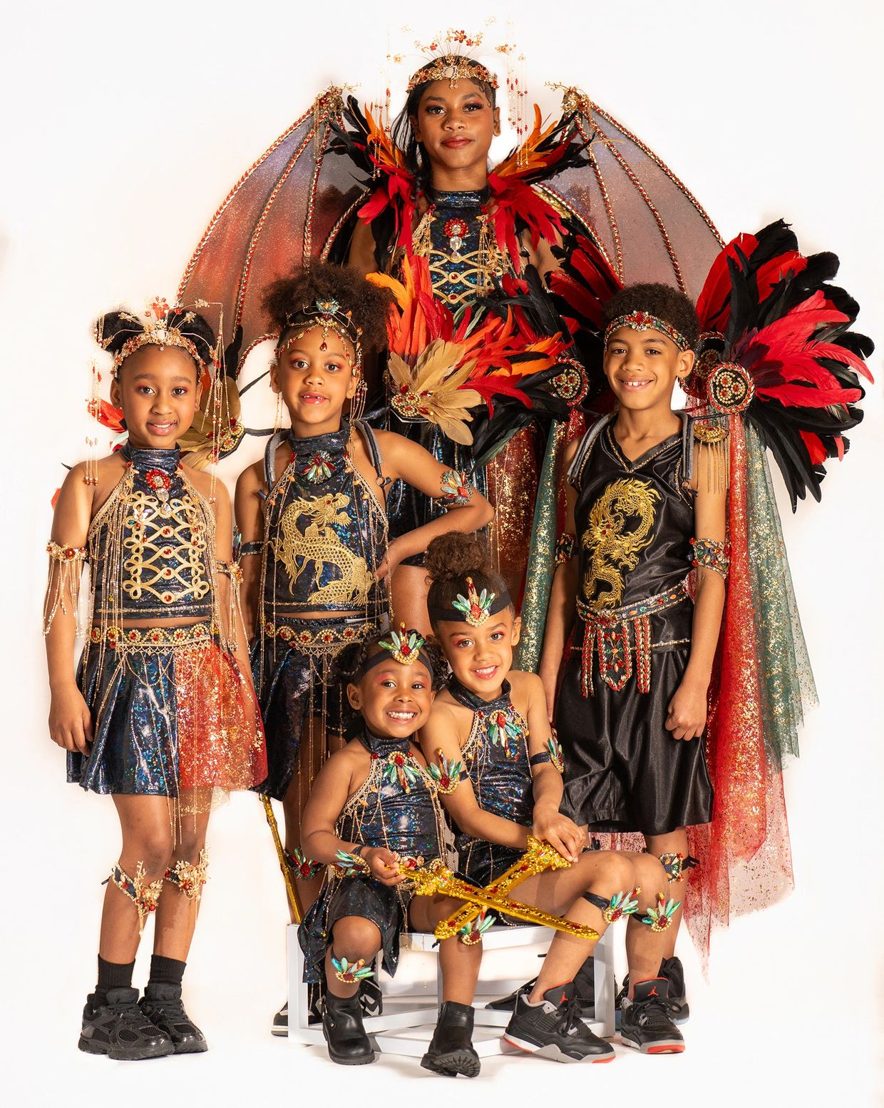 Children in elaborate dragon-themed costumes with wings and headpieces.
