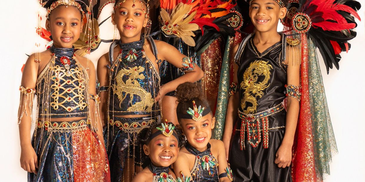 Children in elaborate dragon-themed costumes with wings and headpieces.