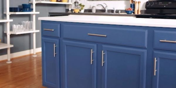 Blue kitchen cabinets with silver handles.