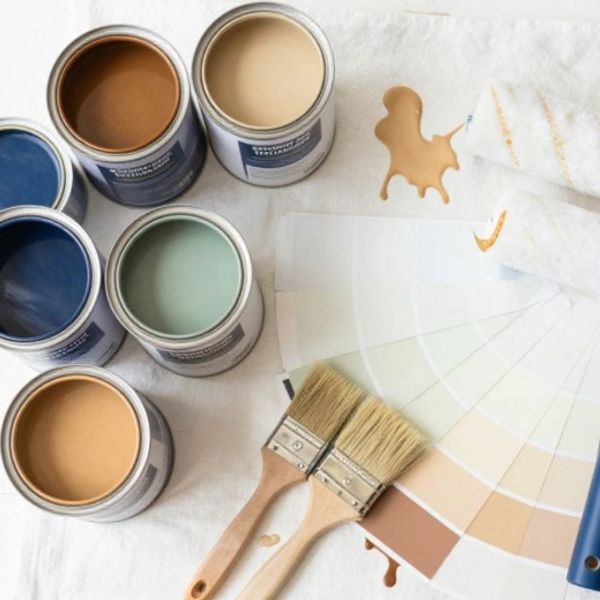 Open paint cans with brushes and color swatches.