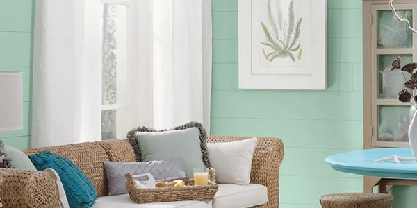 Cozy living room with wicker furniture and pastel decor.