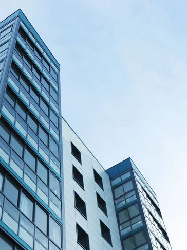Modern glass and steel building under a clear sky.