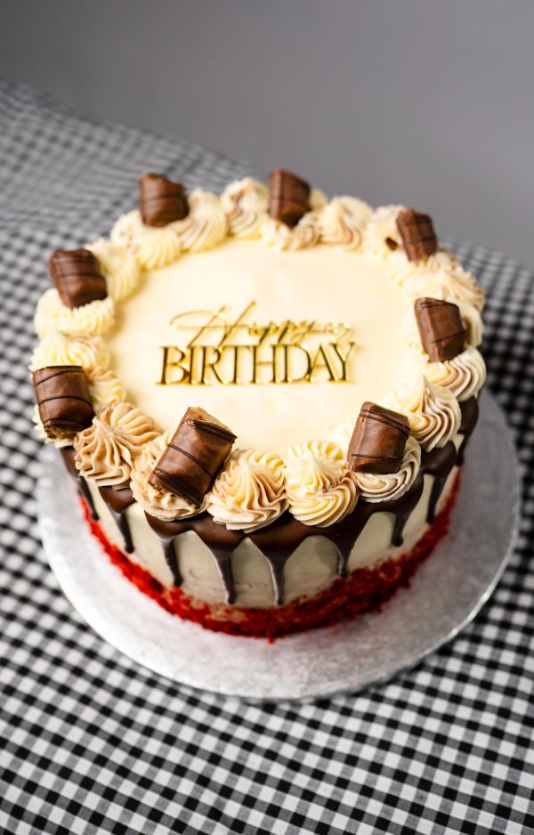 Chocolate birthday cake with creamy frosting and chocolate pieces.