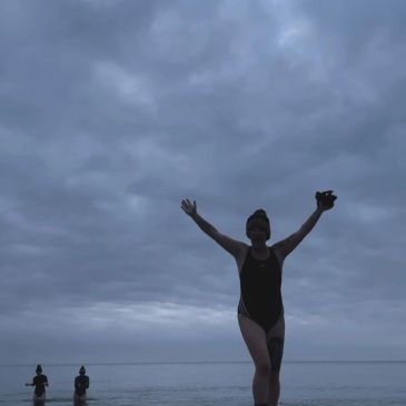 Person enjoying a cloudy beach.
