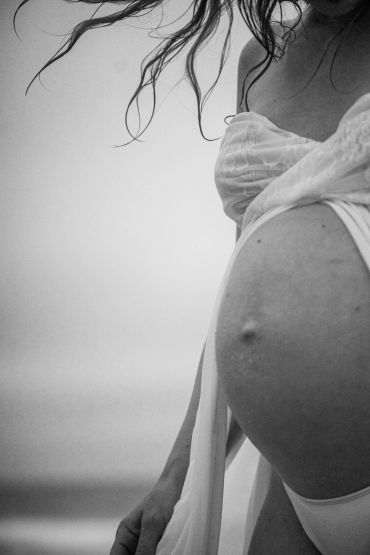 Black and white photo of a pregnant woman from the side.