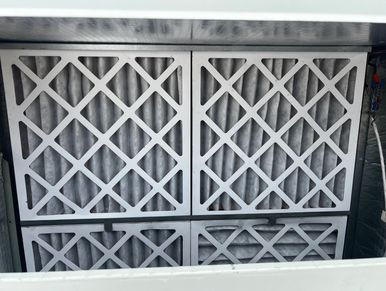 Close-up of four pleated air filters in a metal frame.