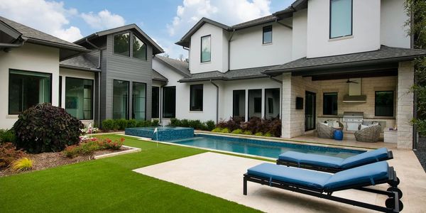 Modern backyard with a pool, lounge chairs, and outdoor seating area.