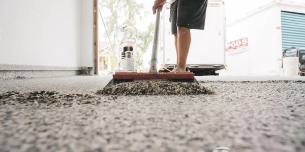 Penntek certified installer scraping the flake on a Penntek floor system in a garage.