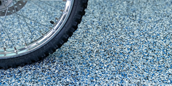 View of a garage floor with a blue and gray flake design, highlighting its durability and aesthetics